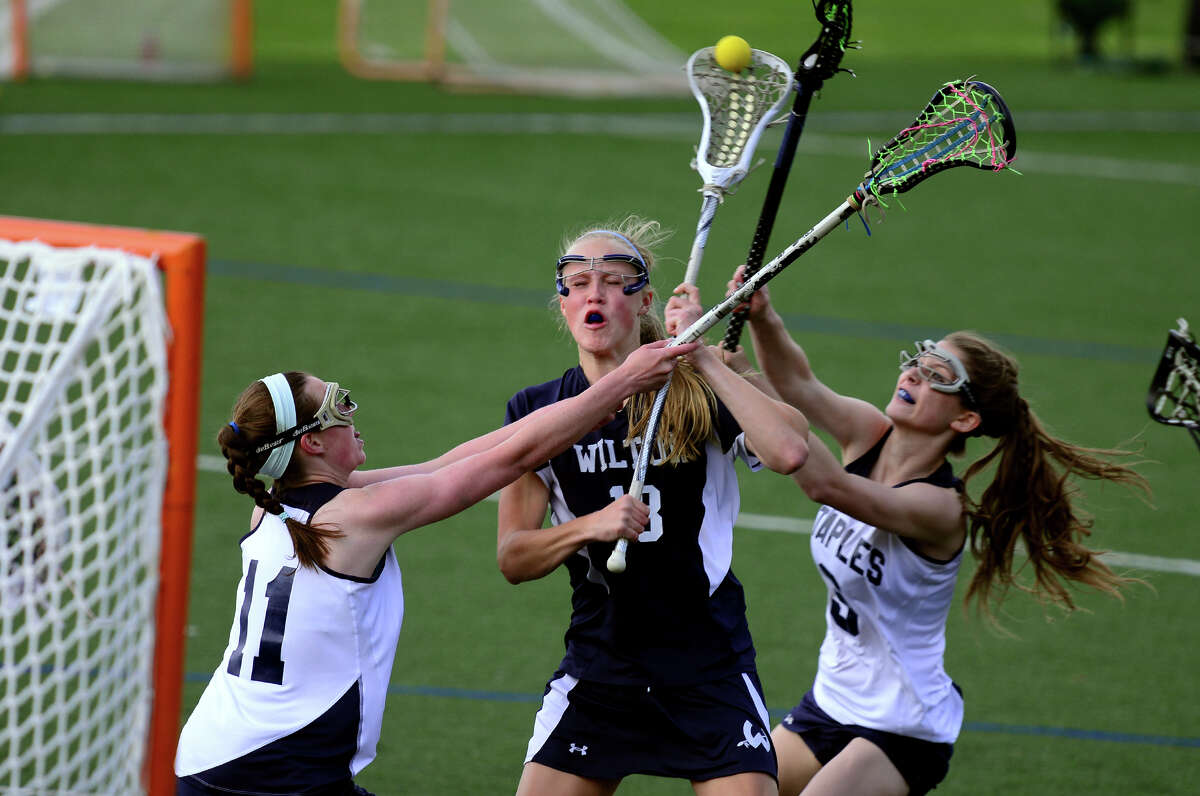 Wilton's Laura Knapp tries to score a goal as Staples' Colleen Bannon, left, and teammate Claire Quigley block, during girls lacrosse action in Westport, Conn. on Tuesday May 6, 2014.