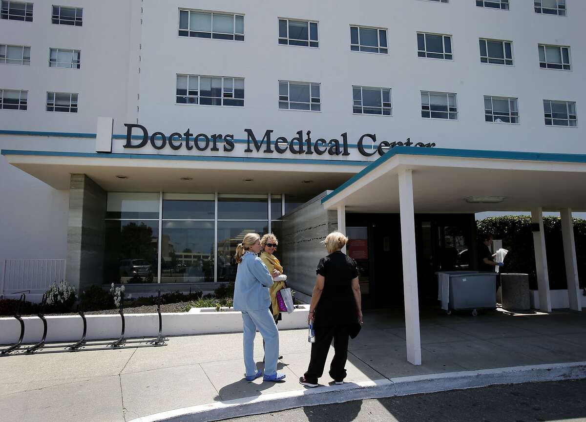 Staff stopped to talk in front of Doctor's Medical Center the day after the vote Wednesday May 7, 2014 in San Pablo, Calif. A measure to keep West Contra Costa County's main hospital and emergency room open was defeated by voters so now Doctor's Medical Center will completely close by summer 2014.