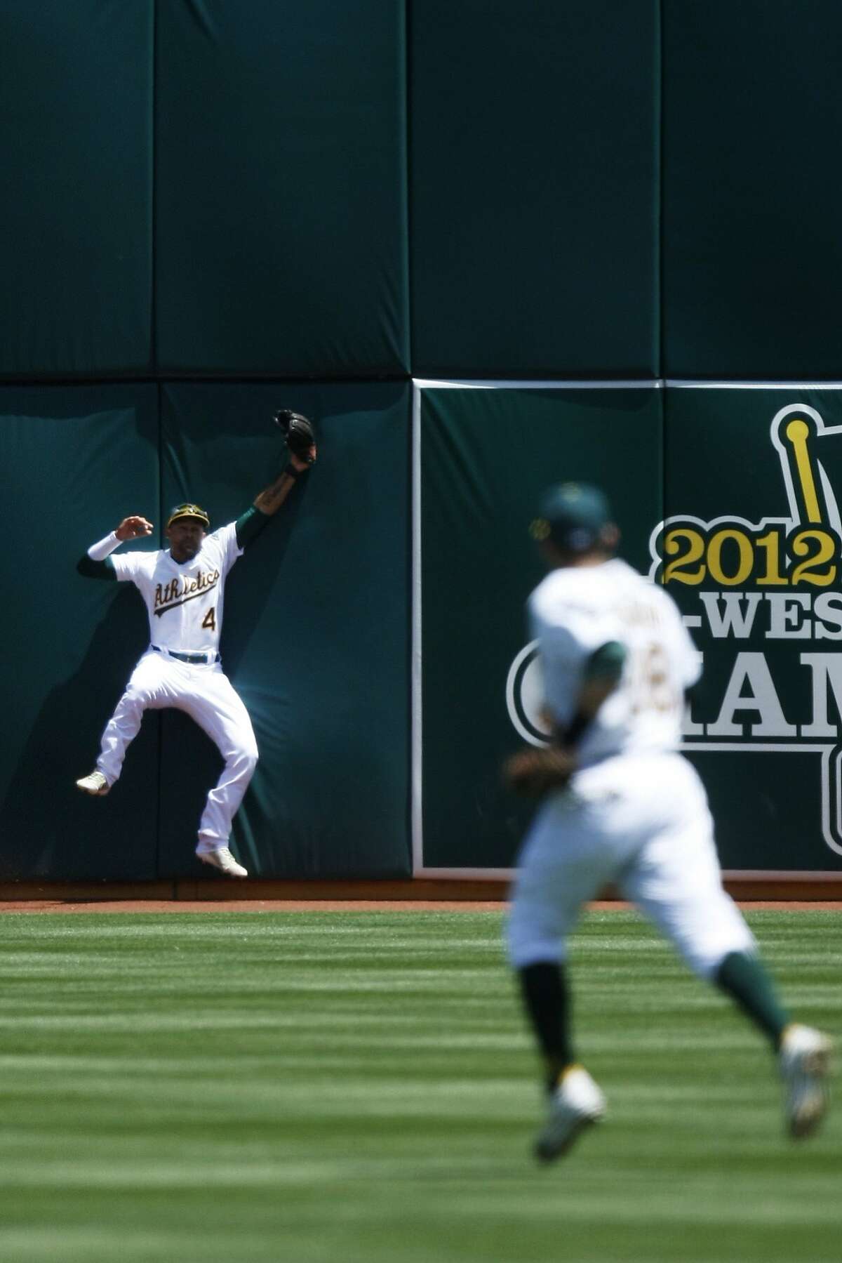 The Athletics' Coco Crisp catches a fly ball from The Mariners' Kyle Seager during the fourth inning of a game between the Oakland A's and the Seattle Mariners at O.co Coliseum on May 7, 2014 in Oakland, Calif. Coco Crisp was injured and taken out of the game on the play.