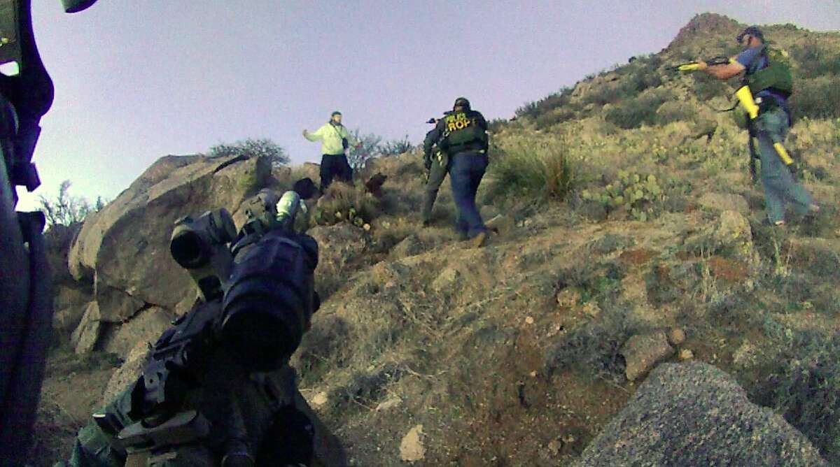 This March 16, 2014 photo, taken from a video camera worn by an Albuquerque Police Department officer, shows police in a standoff with a homeless man in the Albuquerque foothills just before they fired six shots at him. Police say James Boyd, 38, who later died at a hospital, refused to drop a knife and had threatened to kill officers. His death sparked an FBI investigation and a violent street protest that forced the city to call out riot officers. (AP Photo/Albuquerque Police Department)