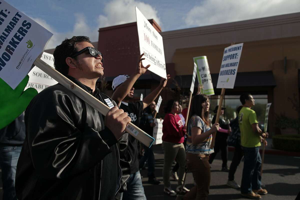 Casey Gallagher, left, chants as he makes his way to the Walmart where President Obama was giving a speech in Mountain View, Calif. on Friday, May 9, 2014. President Obama held a talk at Walmart to discuss green energy.