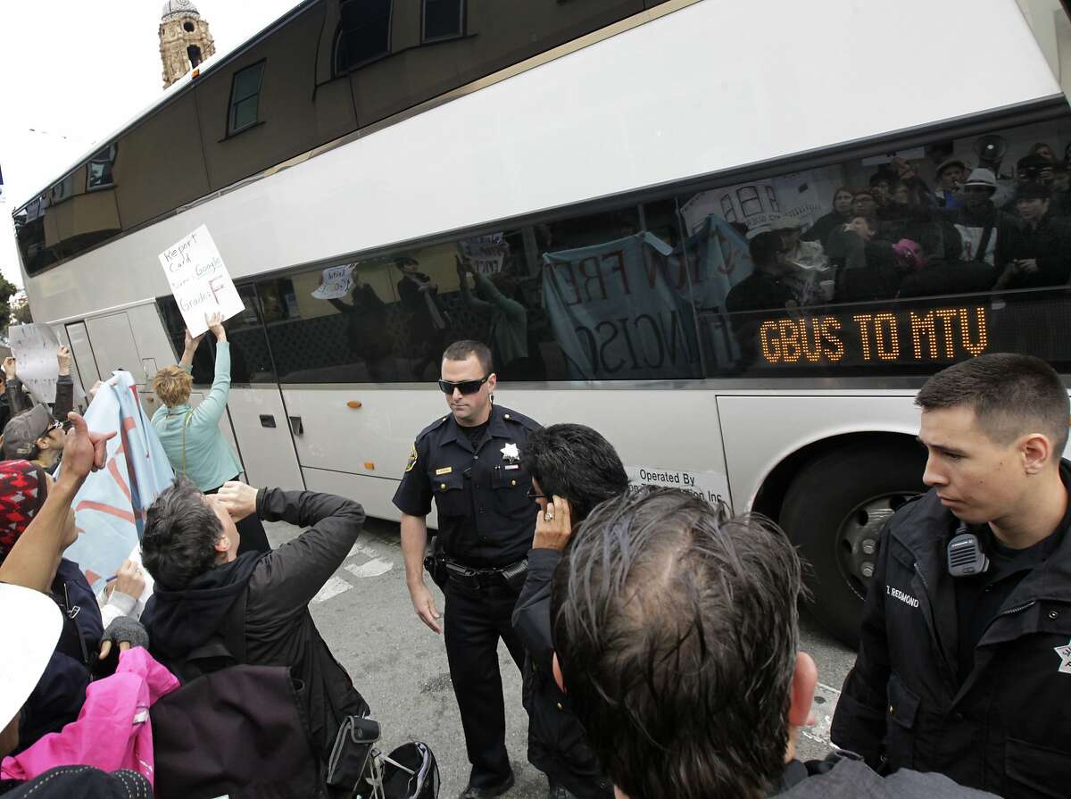 Police officers move in to clear protesters away from a Google bus at 18th and Dolores streets in San Francisco, Calif. on Friday, April 11, 2014. The demonstrators are angry with the high number of Ellis Act evictions on tenants.