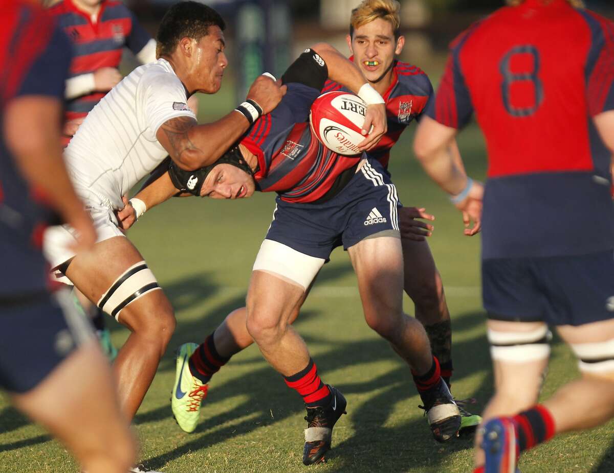 St Mary's Cooper Maloney, center, is tackled as he drives the ball May 10, 2014 during the Men?•s Division I-A National Rugby Championship game of St. Mary?•s College against Life University at Steuber Rugby Stadium in Stanford, Calif.