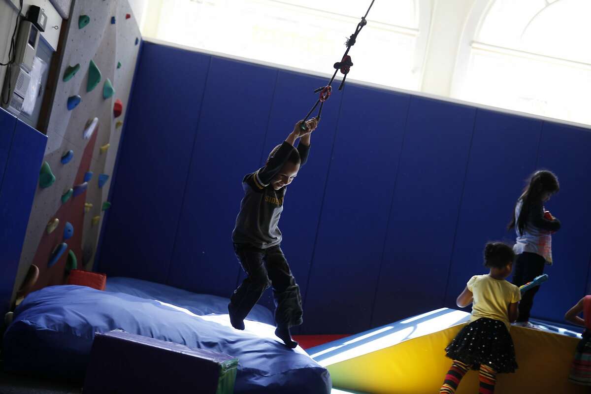 Eduardo Calderon (left), 4, swings on a rope in the Vikasa Room, gross motor activity room, at the Compass Children's Center on Monday, May 12, 2014 in San Francisco, Calif.