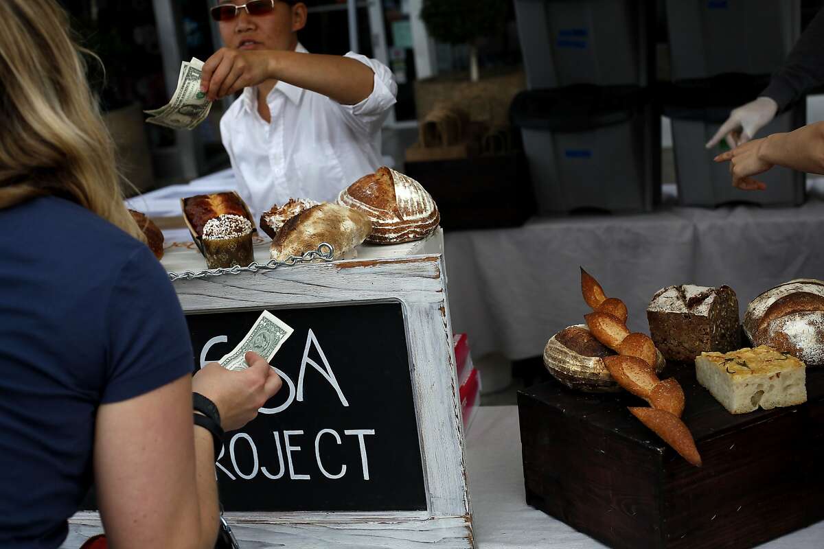 Customers shop at the Manresa Bread Project at the Palo Alto farmer's market in Palo Alto, Calif., on Sunday, May 4, 2014.