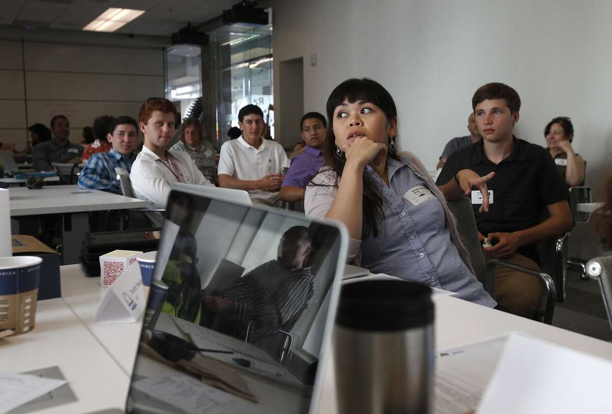 Dorothy Morallos, right center, from James Lick Middle School, listens to a teacher ask a question about 3D modeling to the presenter, Steve Temple, from San Rafael High School (not pictured) during the Design the Future--SFUSD: Integrating 3D Modeling into the Curriculum workshop May 13, 2014 at the Autodesk gallery in San Francisco, Calif.