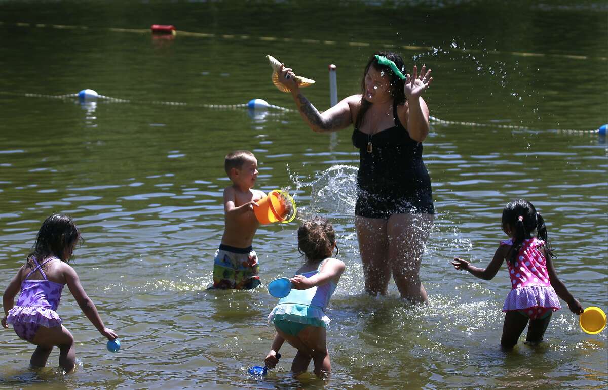 In this file photo people splashing water to keep cool at Lake Temescal in Oakland, Calif. on Tuesday, May 13, 2014.