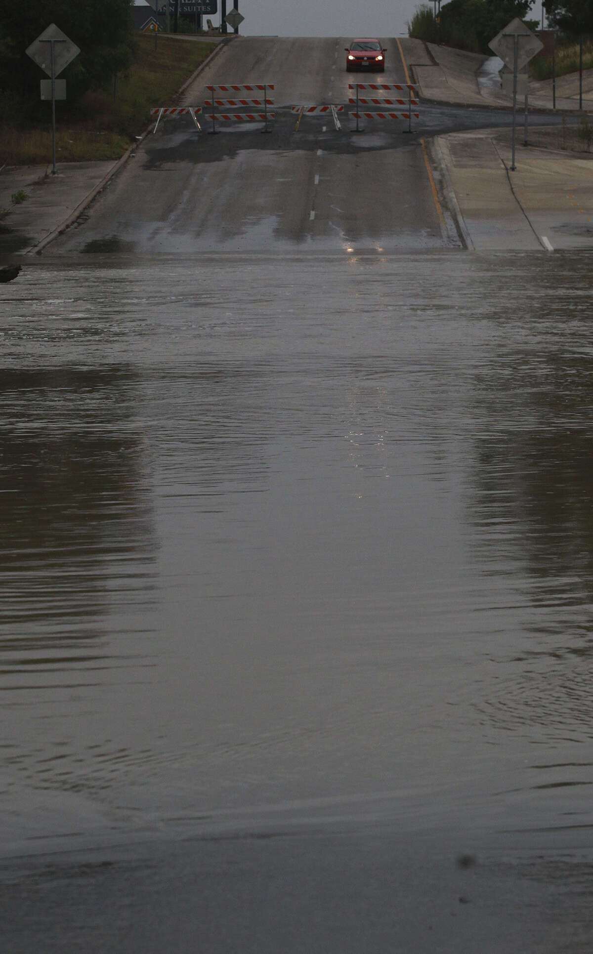 A motorist pauses near debris in the road close to Salado Creek and Interstate 35 after the area flooded from the thunder- storm. Heavy rain caused many San Antonio roads to be shut down late Monday and into Tuesday.