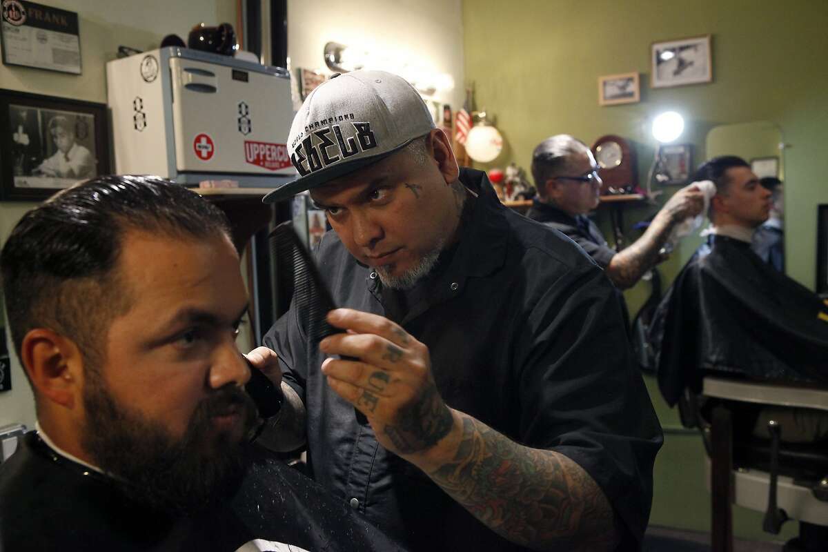Owner Frank Santiago, center, cuts the hair of Cisco Soto at Frank De Barber in Sperry Station in downtown San Jose, CA, Wednesday May 7, 2014.