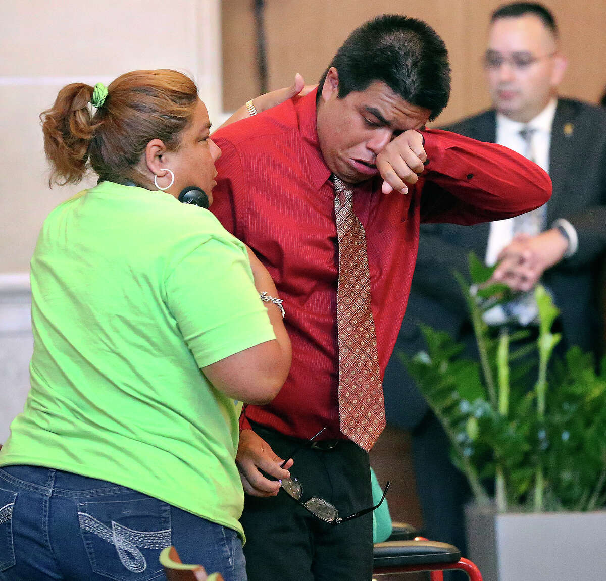 Christian Amador wipes away tears from his passionate plea before council as Adrianna Amador asked him to speak again as District 3 residents listen to city council vote on the rezoning of Mission Trails Mobile Home Park on May 15, 2014.