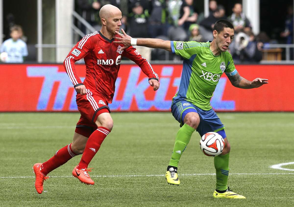 Seattle Sounders' Clint Dempsey, right, tries to hold off Toronto FC's Michael Bradley, left, in the second half of an MLS soccer match on Saturday, March 15, 2014, in Seattle. Toronto won 2-1. (AP Photo/Ted S. Warren)