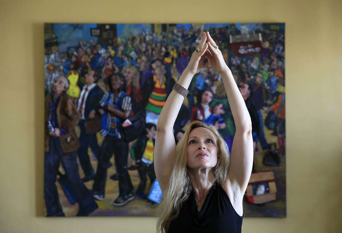 Artist Nancy Calef, who is releasing her illustrated memoir "Peoplescapes: My Story from Purging to Painting", strikes a yoga pose in front of her artwork in her home on Thursday, May 15, 2014 in San Francisco, Calif.