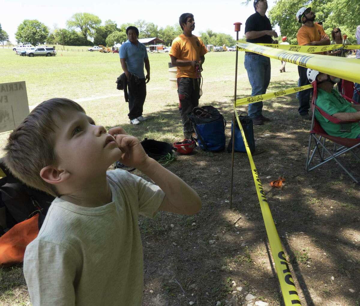 Topher Nelson, 6, watches as climbers compete in the Texas Tree Climbing Championship in New Braunfels. Events include the throw line, foot lock, aerial rescue and work climb.