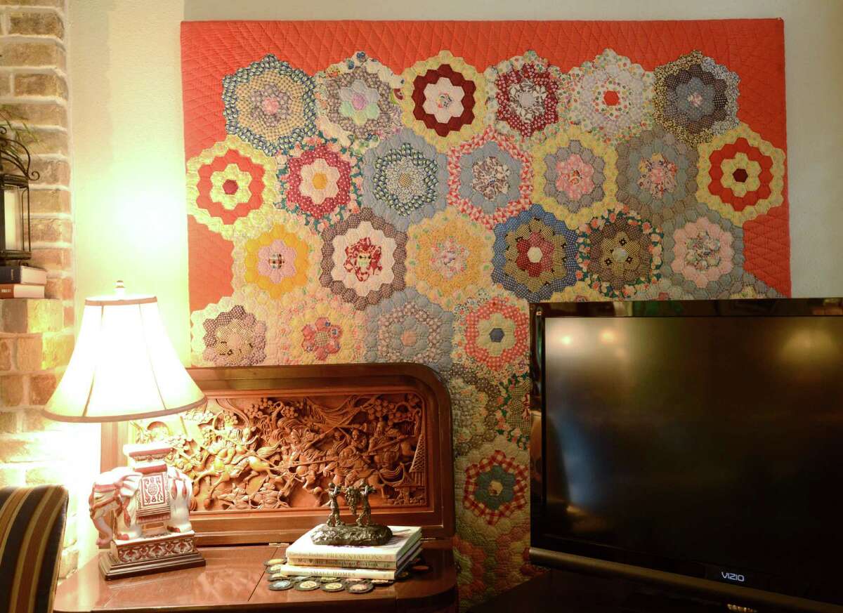 An antique quilt bought at an estate sale adorns a living room wall in the home of Susan and Stan Marett.