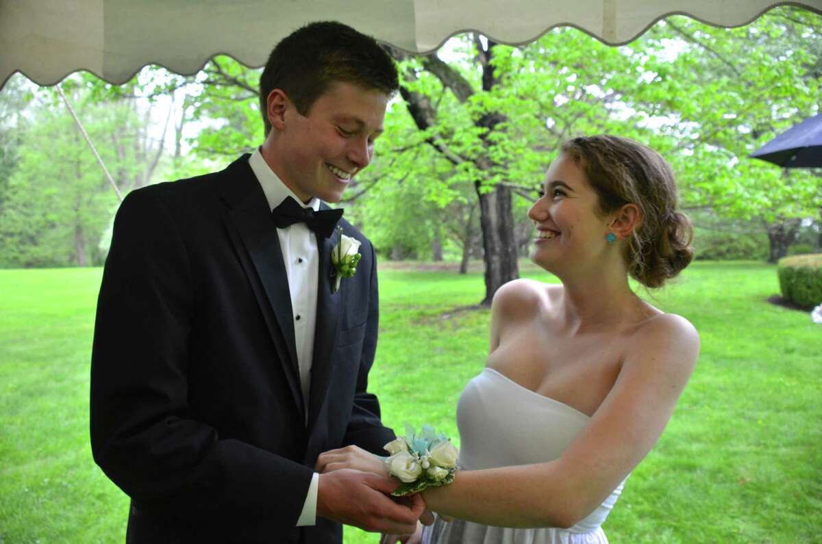 Henry Holbrook and Charlotte Rosenberg exchange boutonniere and corsage at a New Canaan High School senior pre-prom party on May 16, 2014.
