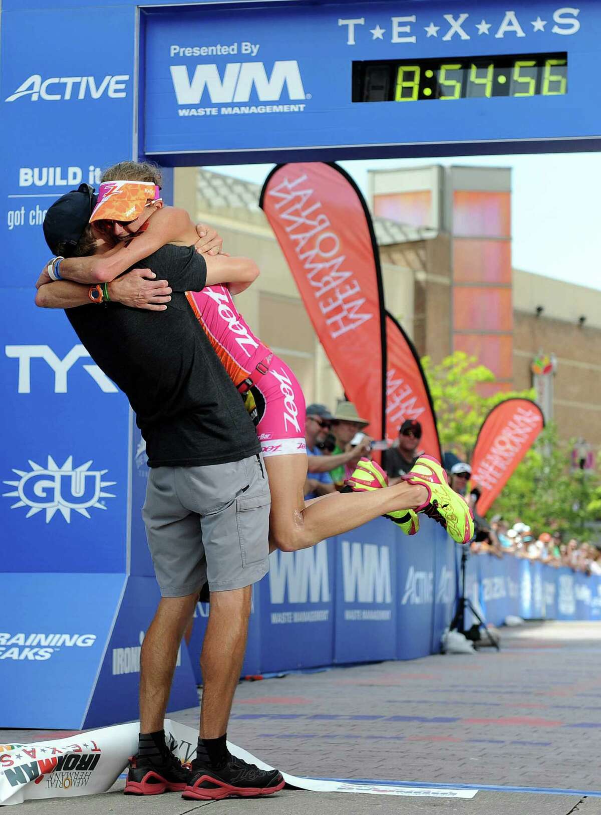 Winner Bevan Docherty holds the finish-line tape after the Memorial Hermann Ironman Texas.
