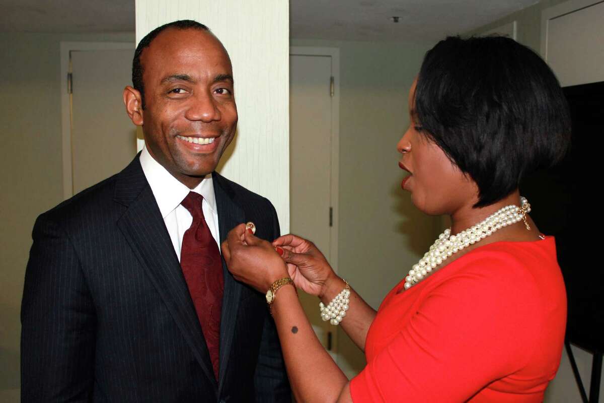 CORRECTS MIDDLE NAME TO WILLIAM - In this image provided by the NAACP, Roslyn Brock, right, chairman of the national board of directors for the NAACP, puts a NAACP pin on new national president and CEO, Cornell William Brooks on Saturday, May 17, 2014, in Ft. Lauderdale, Fla. The selection of Brooks came as the United States marked the 60th anniversary of the Brown v. Board of Education decision by the U.S. Supreme Court, which outlawed segregation in public schools. The lawsuit was argued by the organization's legal arm. (AP Photo/NAACP, J. Adams)