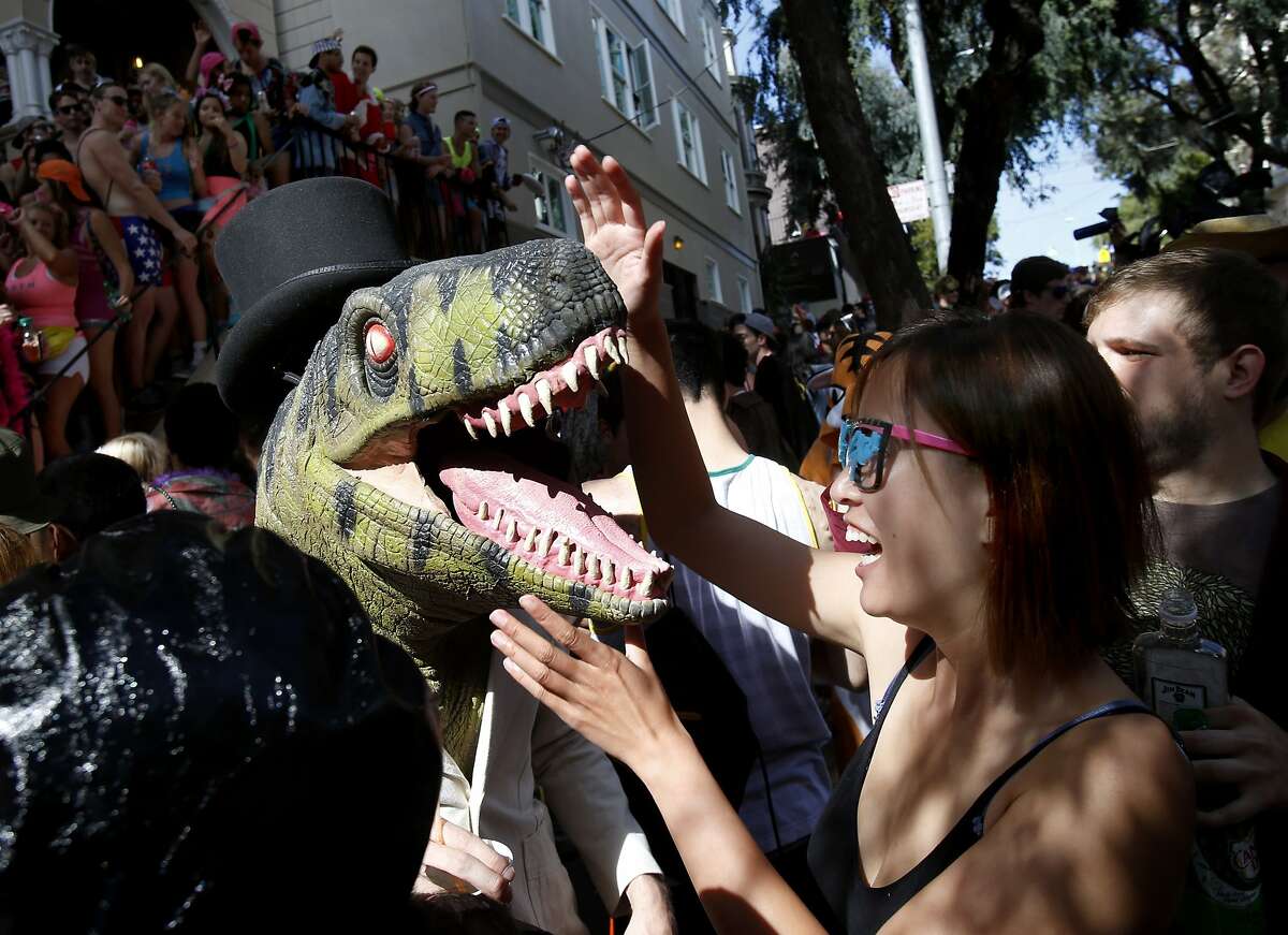 A woman tried to deal with a prehistoric runner in front of a large party of Hayes Street. The annual Bay to Breakers event in San Francisco, Calif. attracted thousands of runners and revelers as they made their way up the Hayes Street Hill Sunday May 18, 2014.