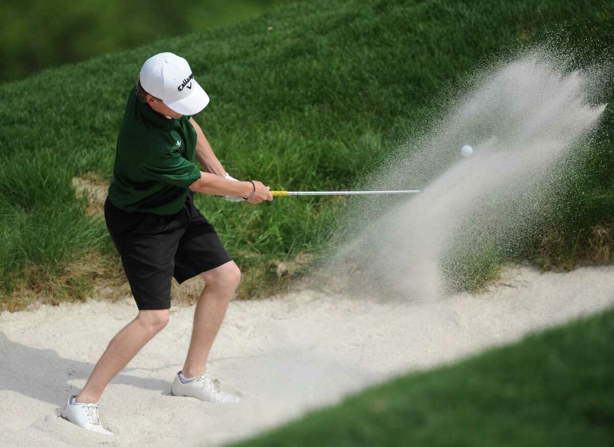 New Milford's Cole Case hits out of a bunker in the high school boys golf match between New Milford and Bethel at Redding Country Club in West Redding, Conn. Wednesday, May 21, 2014.
