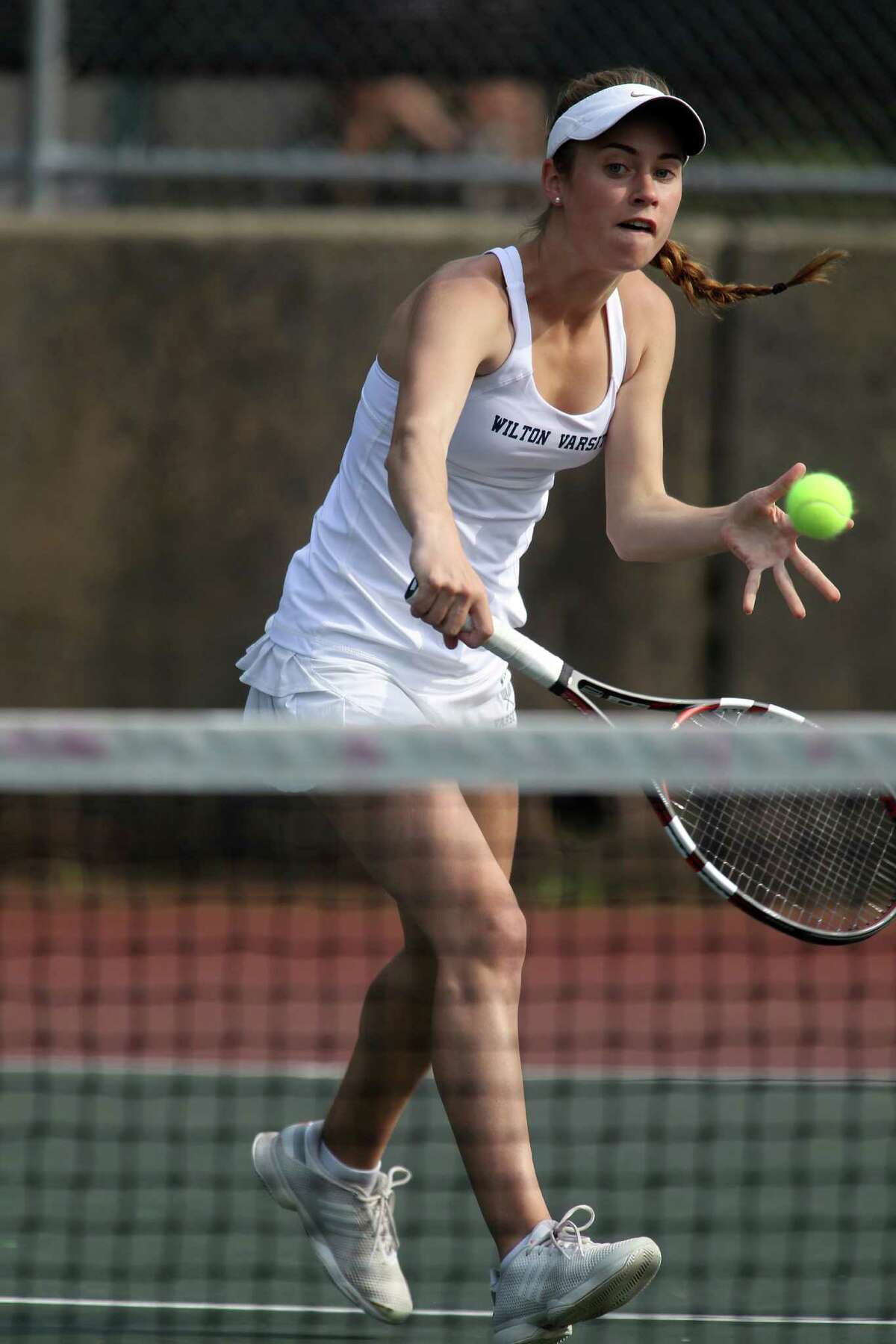 Maddie Stow of Wilton returns a volley during her FCIAC tennis match in Greenwich, Conn. on Wednesday, May 21, 2014.