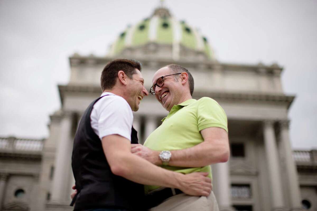 ,Just engaged Jefferson Rougeau, left, Steven Creps embrace on the steps of the state Capitol, Tuesday, May 20, 2014, in Harrisburg, Pa. Pennsylvania's ban on gay marriage was overturned Tuesday by a federal judge in a decision that makes same-sex marriage legal throughout the Northeast. (AP Photo/Matt Rourke) ORG XMIT: PAMR115
