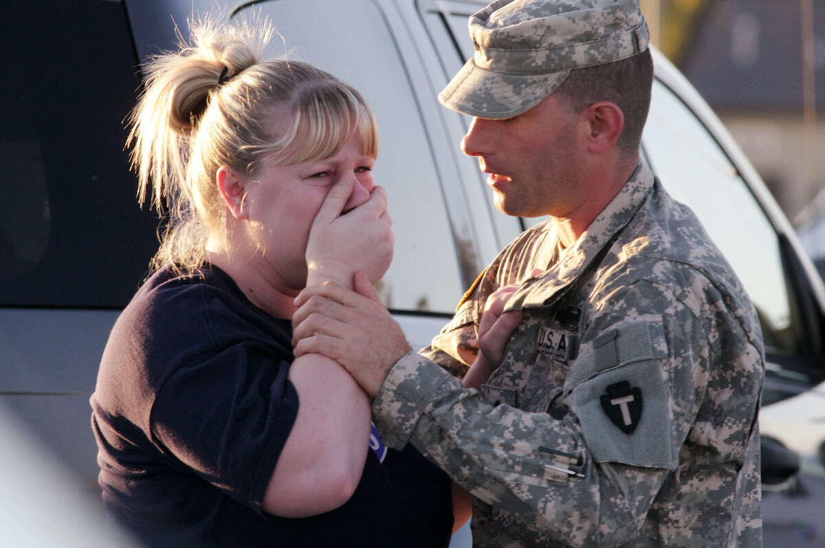 Sgt. Anthony Sills comforts his wife as they wait outside Fort Hood the day of the rampage in 2009.