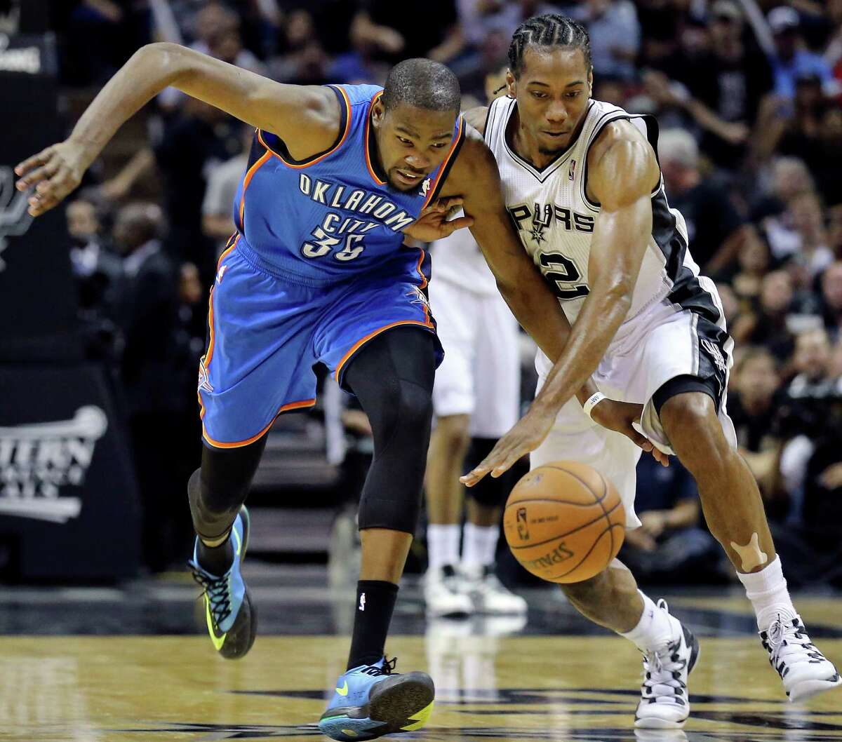 Oklahoma City Thunder's Kevin Durant and San Antonio Spurs' Kawhi Leonard chase after a loose ball during second half action of Game 2 in the Western Conference Finals Wednesday May 21, 2014 at the AT&T Center. The Spurs won 112-77.