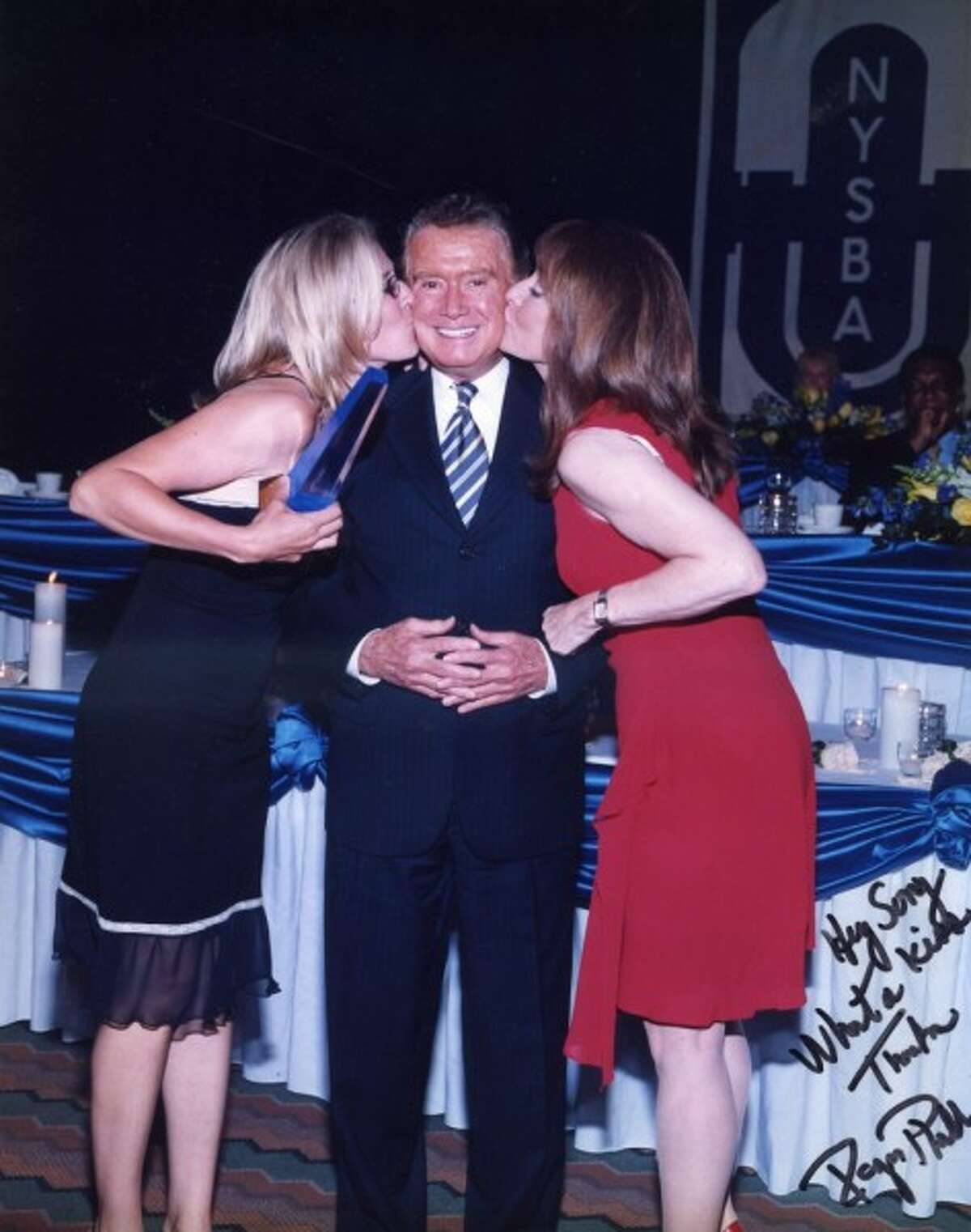 Sonja Stark and Judy Sanders smack a kiss on Regis Philbin after winning a National Broadcasters Award for finding an abducted baby in 1999.