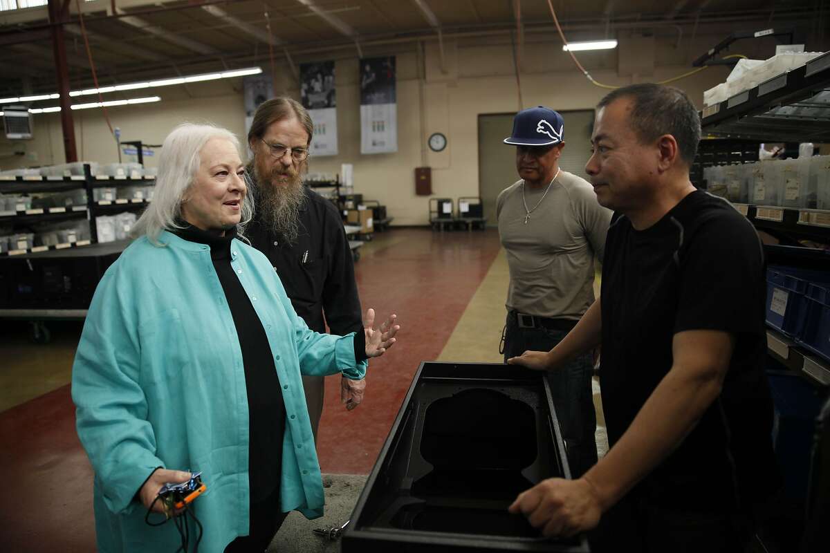 Helen Meyer (left), executive vice president and John Meyer (second from left), president & CEO, and of Meyer Sound Laboratories talk with Buen Guido (right), supplier quality assurance engineer, and other workers as they walk through the factory on Thursday, March 13, 2014, in Berkeley, Calif.