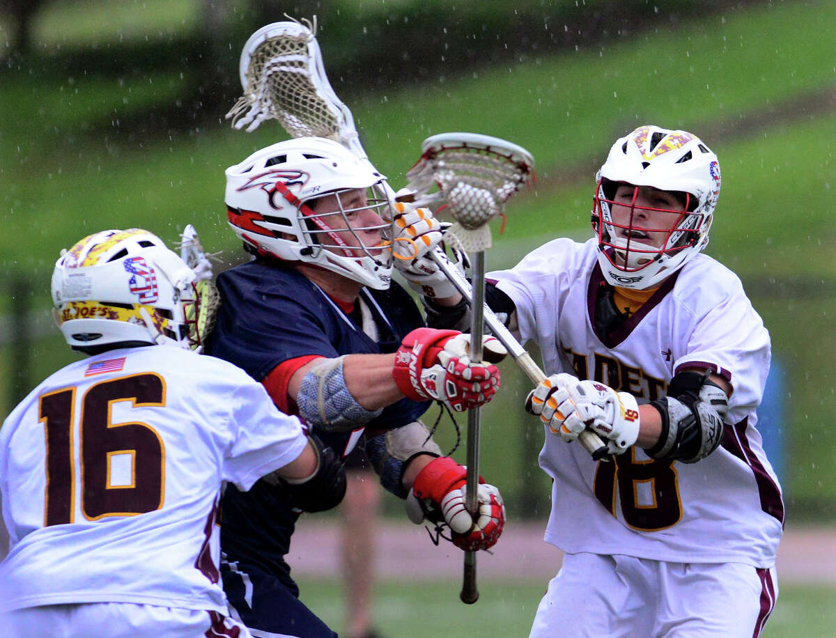 St. Joseph's Mike Brennan, right, and Rick Giordano put the squeeze on Avon's Sean Neagle, during boys lacrosse action in Trumbull, Conn. on Thursday May 22, 2014.