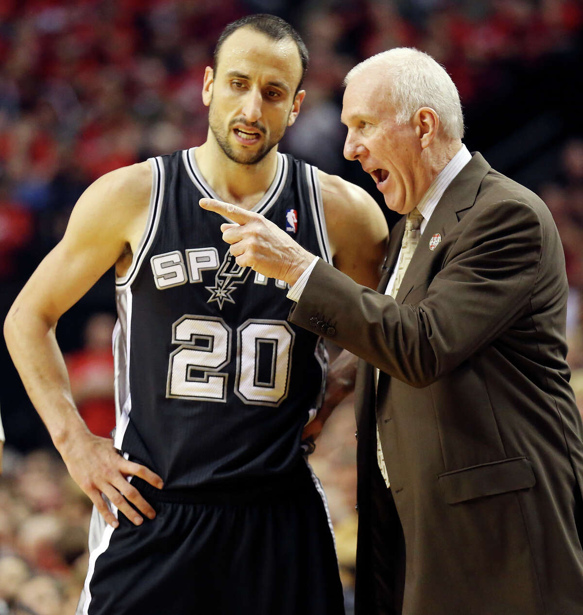 San Antonio Spurs' Manu Ginobili talks with head coach Gregg Popovich during second half action of Game 3 in the Western Conference semifinals Saturday May 10, 2014 at the Moda Center in Portland, OR.