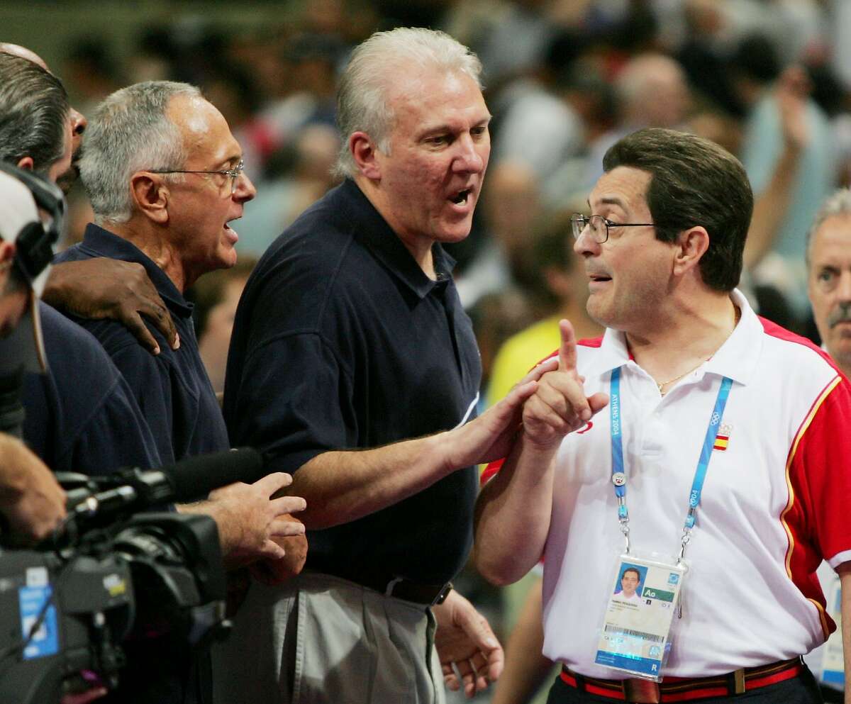 **EDS: RETRANSMITTING TO ADD IDENTIFICATION OF MAN AT CENTER**USA basketball coach Larry Brown, left, is confronted by Spain's coach Mario Pesquera, right, at the conclusion of their quarterfinal game at the Olympic Indoor Hall during the 2004 Summer Olympics in Athens, Greece on Thursday, Aug. 26, 2004. The USA won 102-94. At center is USA assistant coach Gregg Popovich. (AP Photo/Dusan Vranic) Ran on: 08-27-2004 U.S. coach Larry Brown and Spain coach Mario Pesquera (right) trade verbal jabs as Gregg Popovich (center) tries to keep peace.