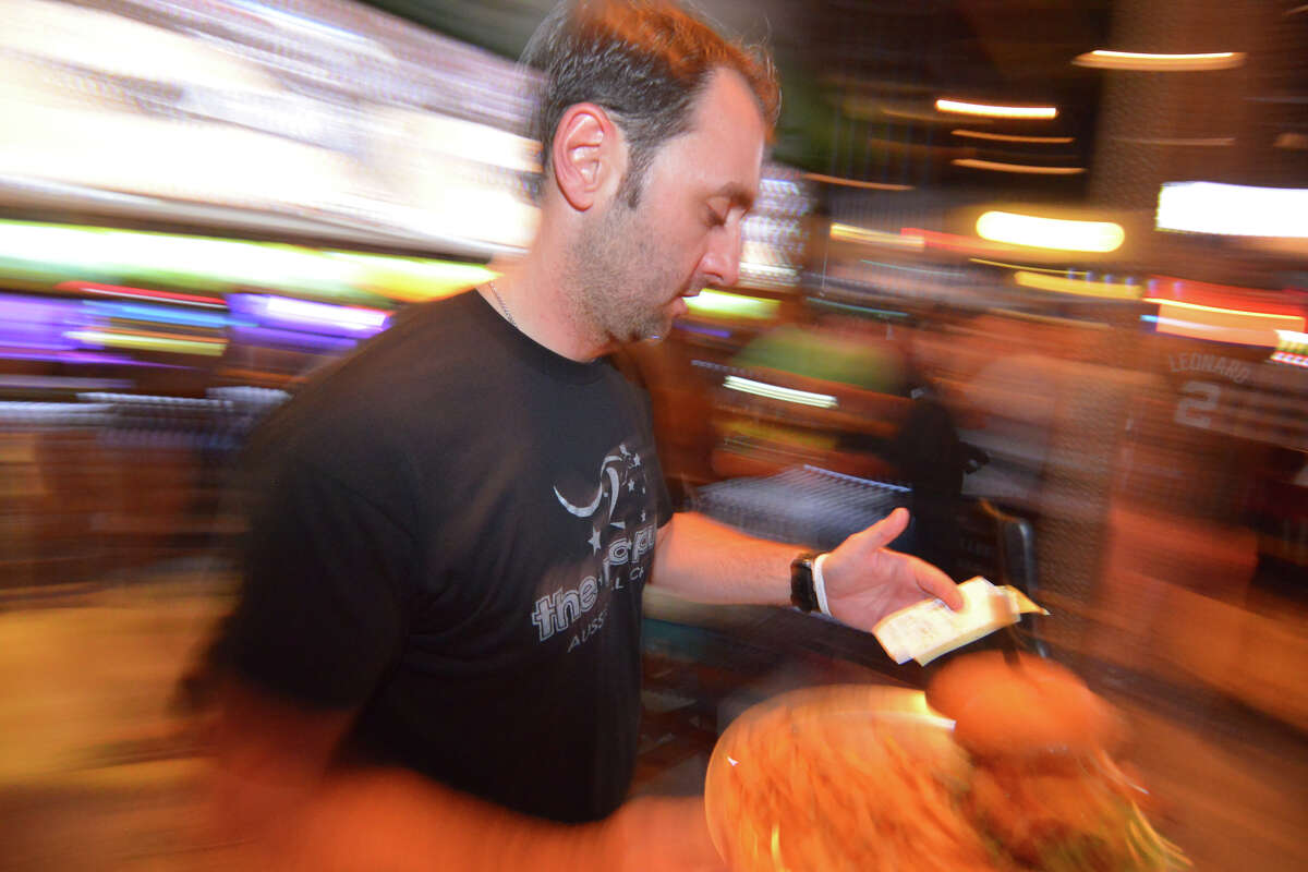 Chip Ingram, owner of the Australian-themed Roo Pub, checks a food order during a crowded night as the Spurs play in Game 2 of the NBA Western Conference Finals against the Thunder.