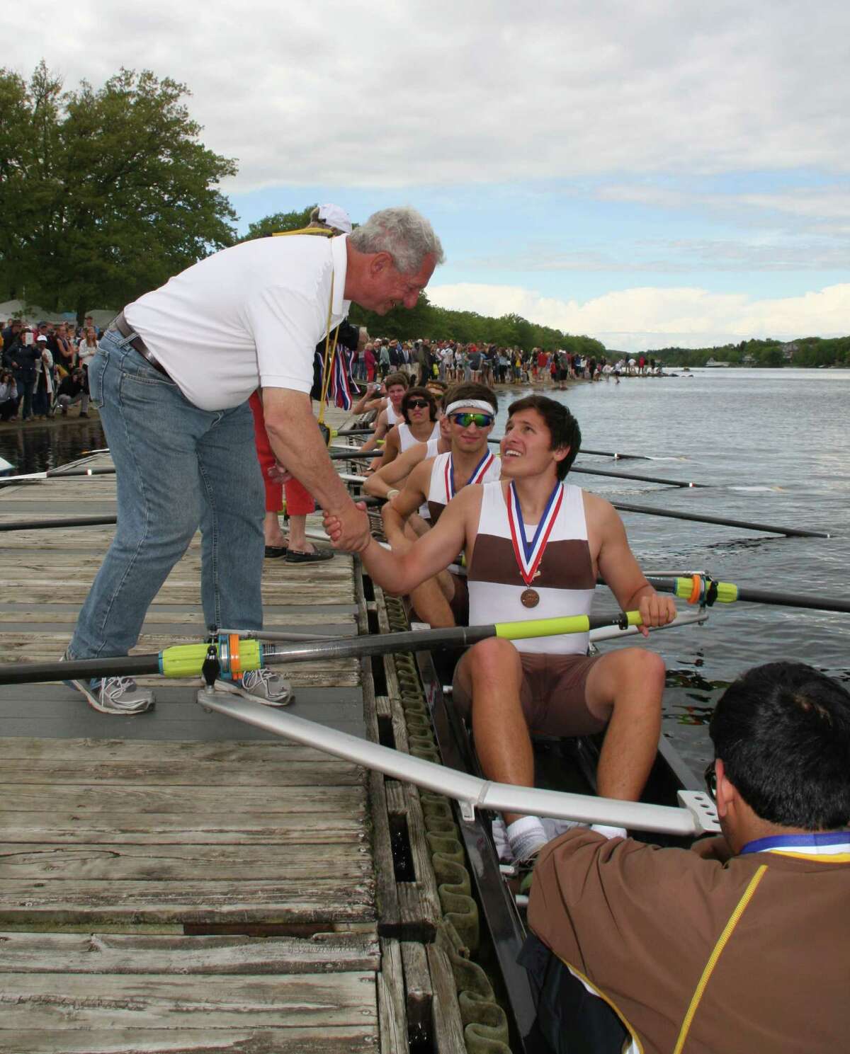 Brunswick crew coach Joe Falco congratulates stroke and senior co-captain Max Skolds after the Bruins took bronze in the NEIRA championships on Saturday, May 24, 2014 at Lake Quinsigamond in Worcester, Mass.
