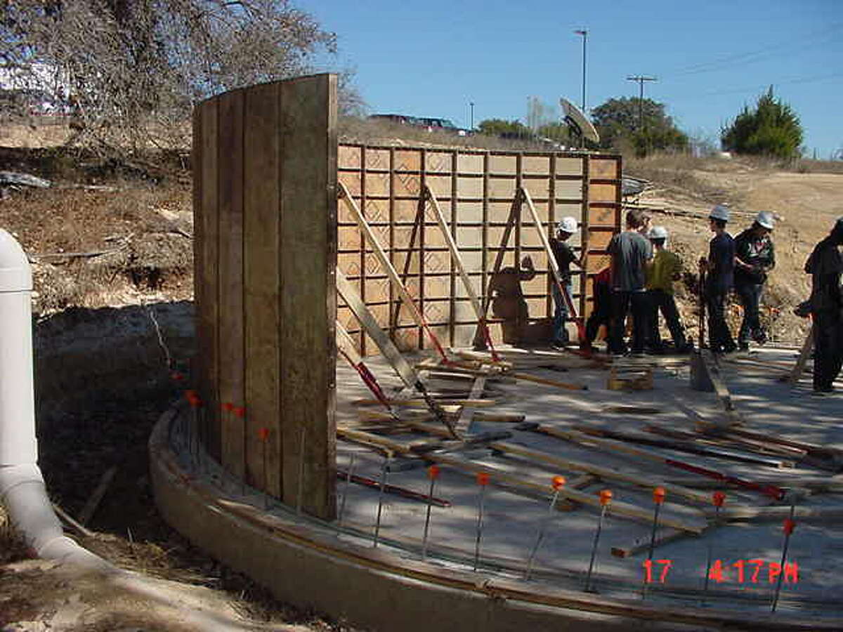 Under the direction of etiring Bandera High School Teacher Brad Flink, students construct a storm water catch system to funnel the storm water run-off from the school's parking lot into what are now two 42,000-gallon tanks.