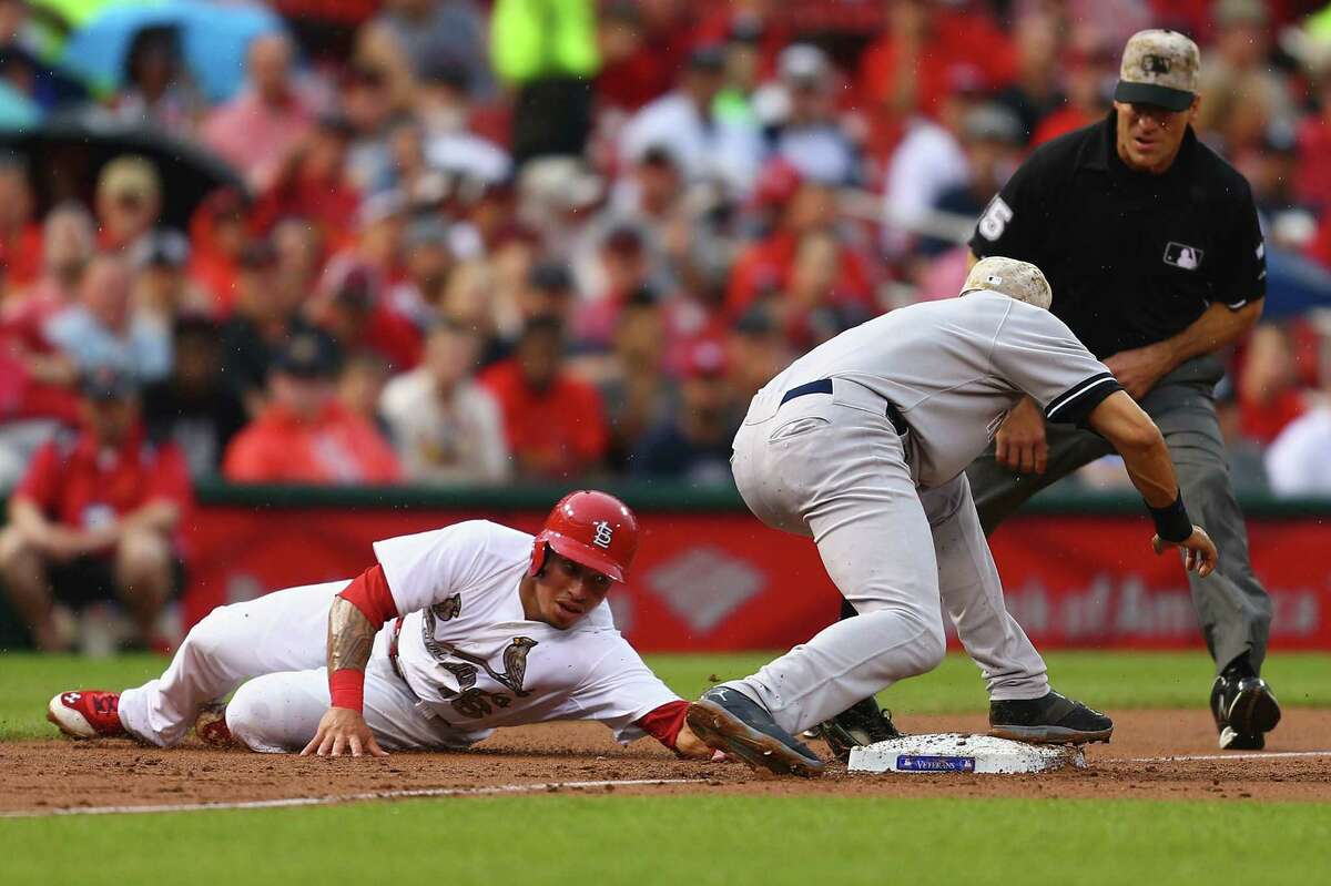 The Yankees' Derek Jeter (right) catches Kolton Wong trying to steal third base in the first inning.
