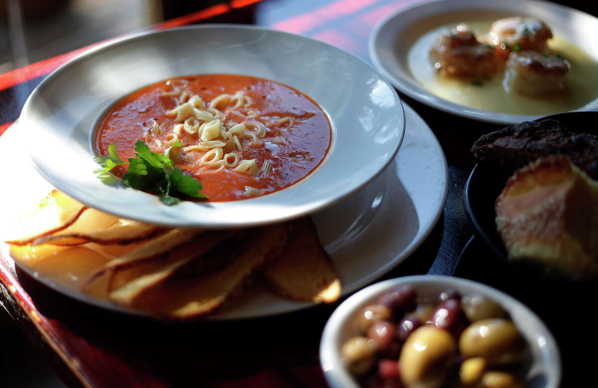 Pasta e fagioli soup surrounded by olives, bread and Paesano's signature dish, shrimp Paesano