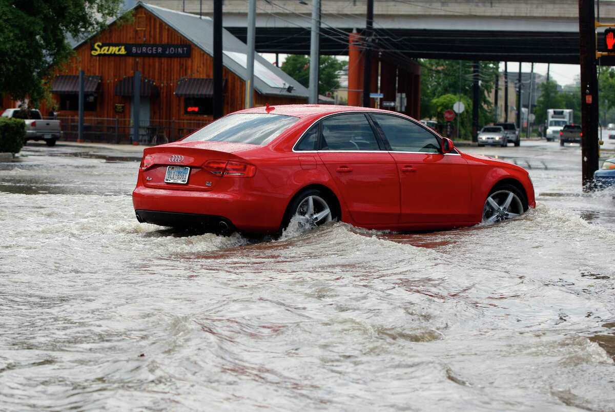 A car tries to navigate Tuesday May 27, 2014, the runoff-flooded intersection of Broadway and Grayson Streets.