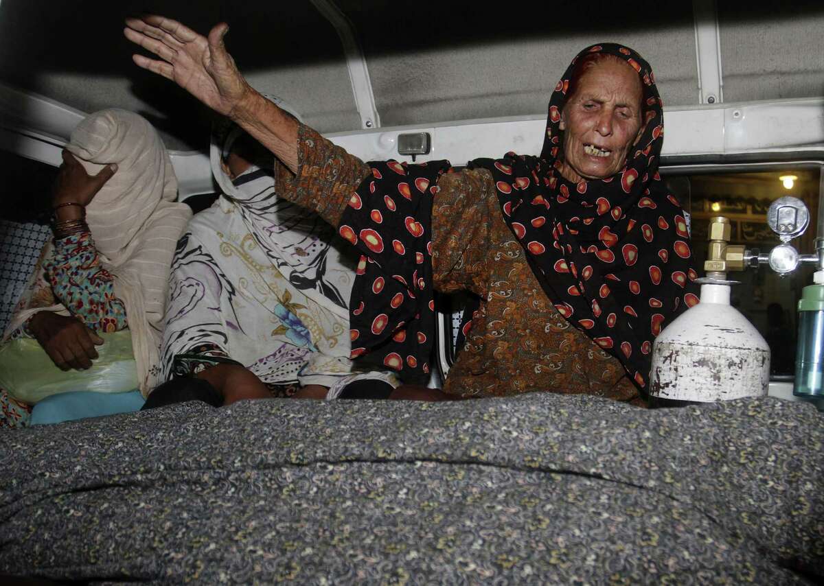 A relative of a woman stoned to death wails over her body in an ambulance in Lahore, Pakistan. Nearly 20 family members, including the woman's father and brothers, attacked her.