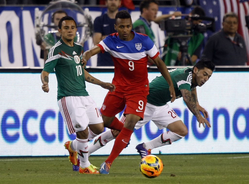 Fulham' s Clint Dempsey, center, dribbles past AS Roma's Marco