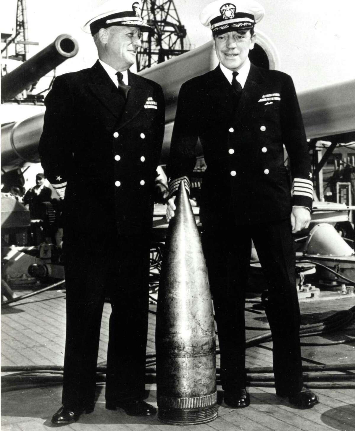 Adm. Carleton F. Bryant (left) and USS Texas Commander Charles Baker show the shell that struck the ship but did not explode.