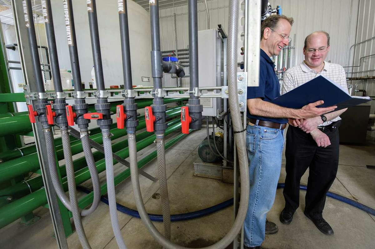 Manure water In this May 21, 2014 photo released by Michigan State University, Jim Wallace and Steven Safferman are shown at a dairy farm where they have helped to convert manure into clean water. A technology for extracting drinkable water from manure is on its way to commercial application this year, Michigan State University 