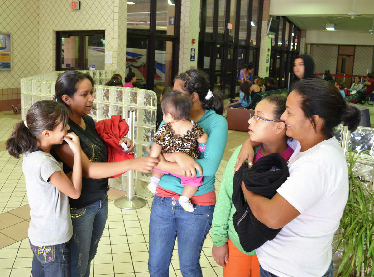 Guatemalan immigrant Flor Garcia, 34, on left in black, talks with other immigrants at the Greyhound bus station in Laredo. The women and their children were caught crossing the border illegally in the Rio Grande Valley, bused to Laredo for processing, then dropped off by U.S. officials at the bus station.