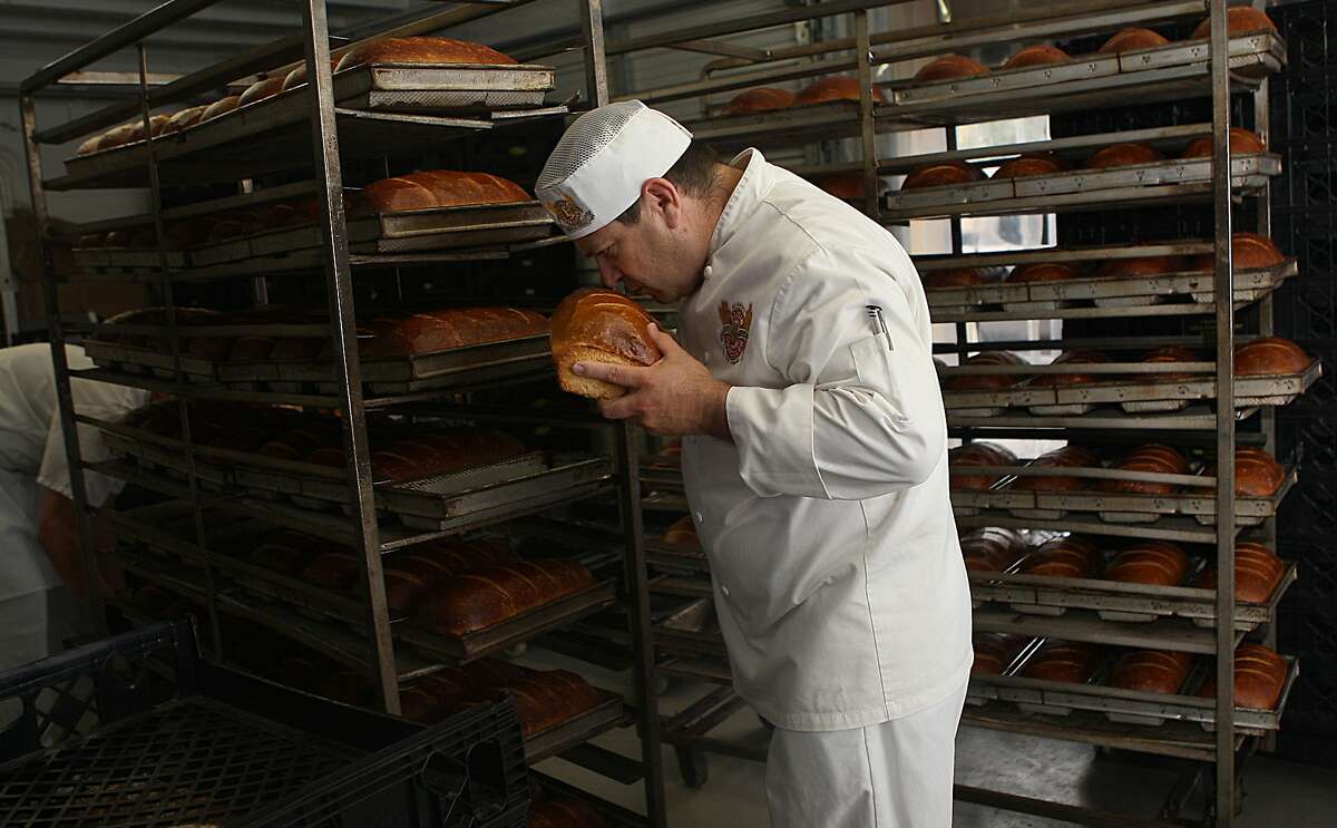 Master baker Fernando Padilla smells some freshly baked loaves as they cool.