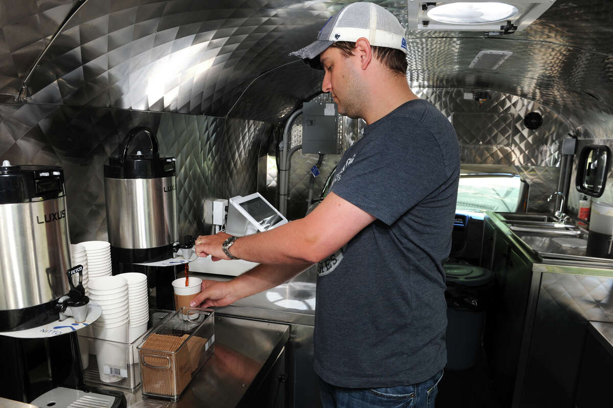 Alex Grutkowski fills a cup of coffee inside of The Buzz Truck, a converted school bus and mobile coffee shop that he and his wife Jessica own, seen here at the Earthplace Nature Center, in Westport, Conn. May 29, 2014.