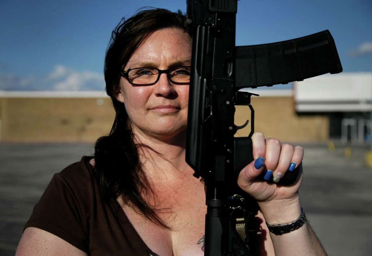 Tara Cowan of Euless, Texas, a member of Open Carry Tarrant County, poses for a portrait with a Saiga 556 rifle as she and members of the group Open Carry Tarrant County gathered for a demonstration, Thursday, May 29, 2014, in Haltom City, Texas. North Texas gun rights advocates are suing the city of Arlington for amending an ordinance that they claim is discriminatory and infringes upon free speech rights, in the latest sign of growing tensions among gun activists and government forces in Texas. (AP Photo/Tony Gutierrez)