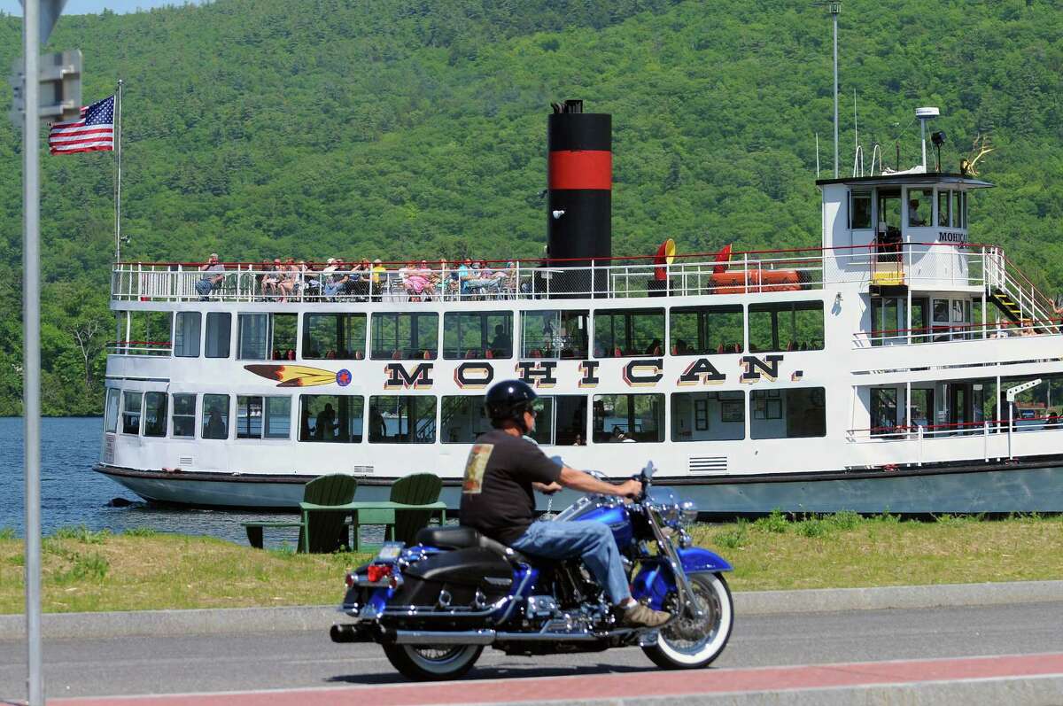 The tour boat Mohican heads out into Lake George as an Americade rider goes by on Monday, June 2, 2014, in Lake George, N.Y. 