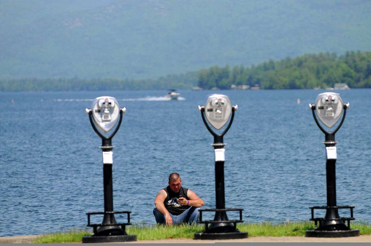 Americade rider, Alan Sawn of Queensbury, sits on the edge of Lake George as he took in some sun on Monday, June 2, 2014, in Lake George, N.Y. 