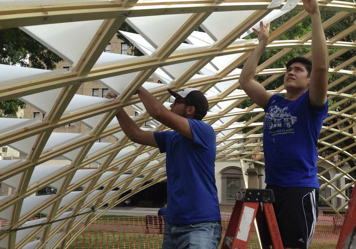 Grad students from UTSA's College of Architecture work on the project. Recent rains helped them bend the wood to fit.