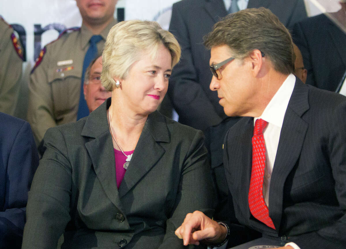 Mayor Annise Parker, left, and Governor Rick Perry talk before a news conference at City Hall announcing an Anti-human trafficking campaign, Tuesday, June 3, 2014, in Houston.
